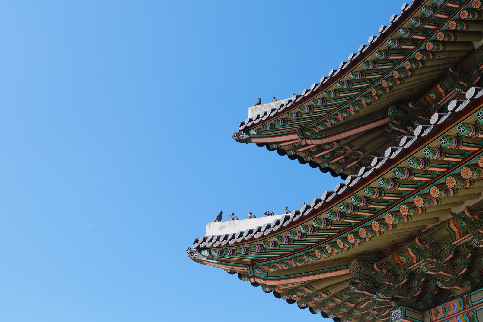 Curved eaves of a Korean palace roof against open sky